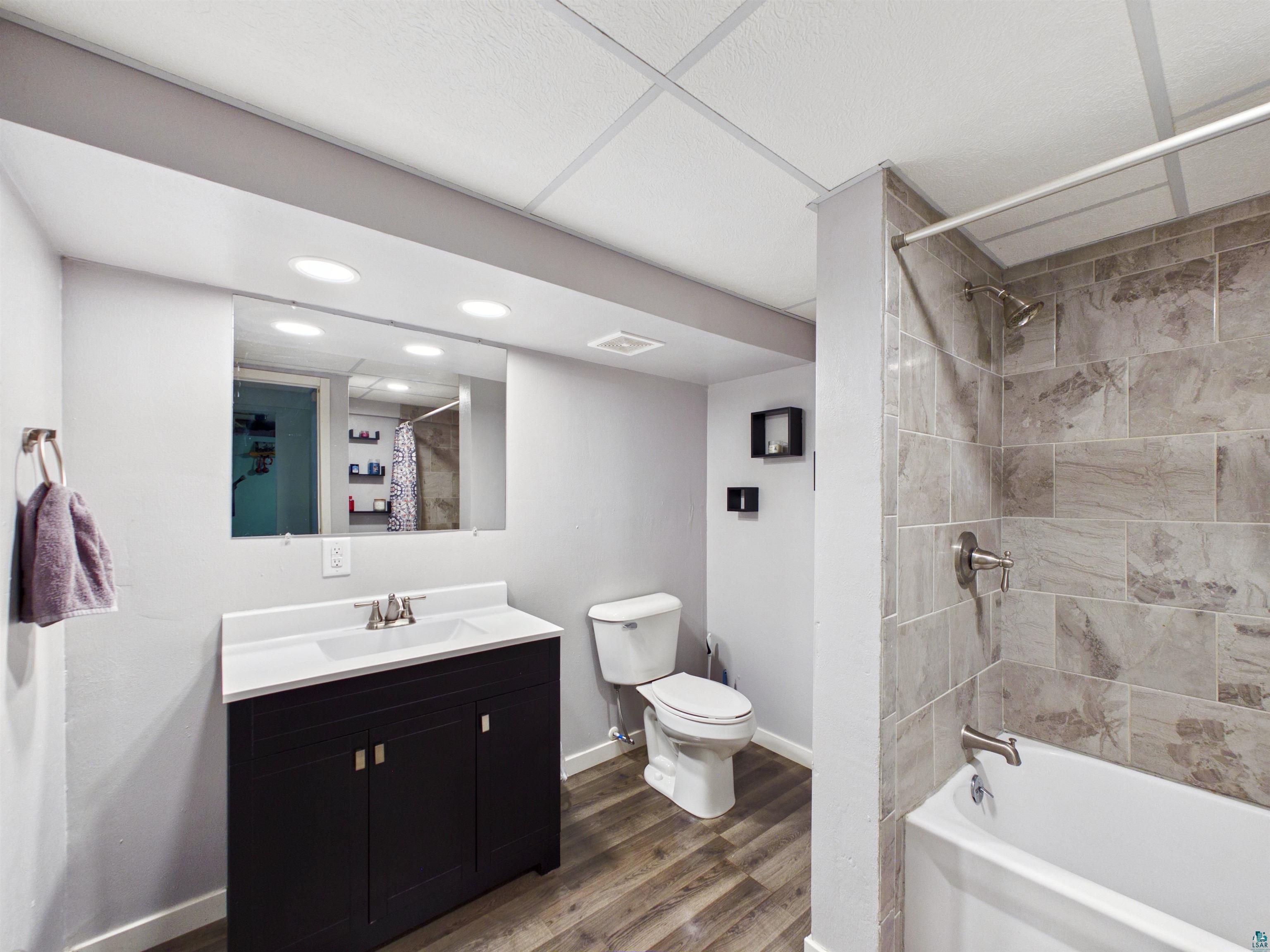 10719 North Oak Ridge Street Hayward, WI 54843 - Photo 42 of 57 Bathroom with vanity, shower / tub combo with curtain, dark wood finished floors, and recessed lighting