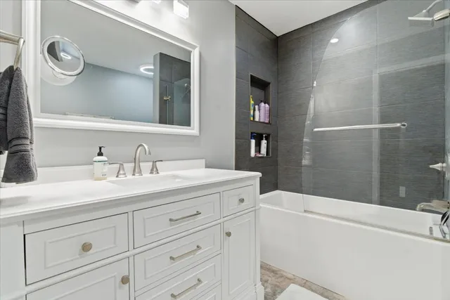 a bathroom with a granite countertop sink a toilet a mirror and shower