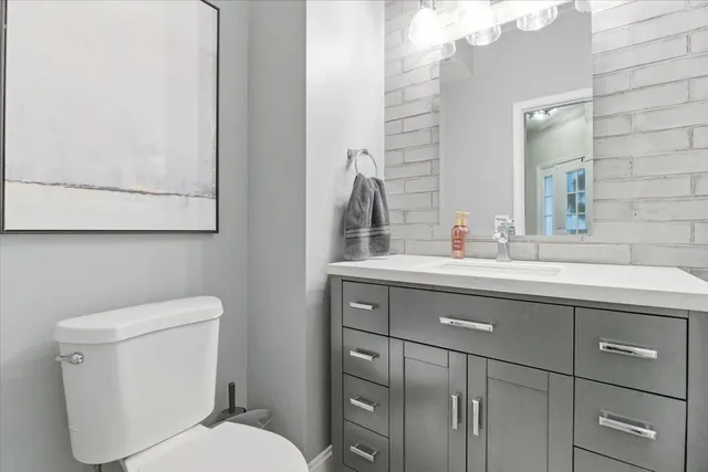 a bathroom with a toilet a sink and mirror