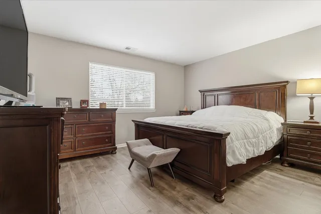a bedroom with a bed and wooden floor