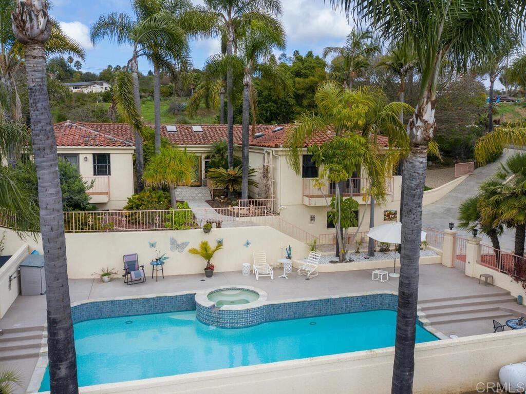 a view of a house with swimming pool and sitting area
