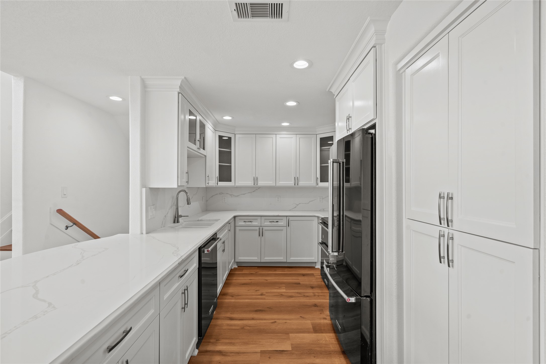 407 Isles End Road Tiki Island, TX 77554 - Photo 12 of 34 a kitchen with a refrigerator and white cabinets