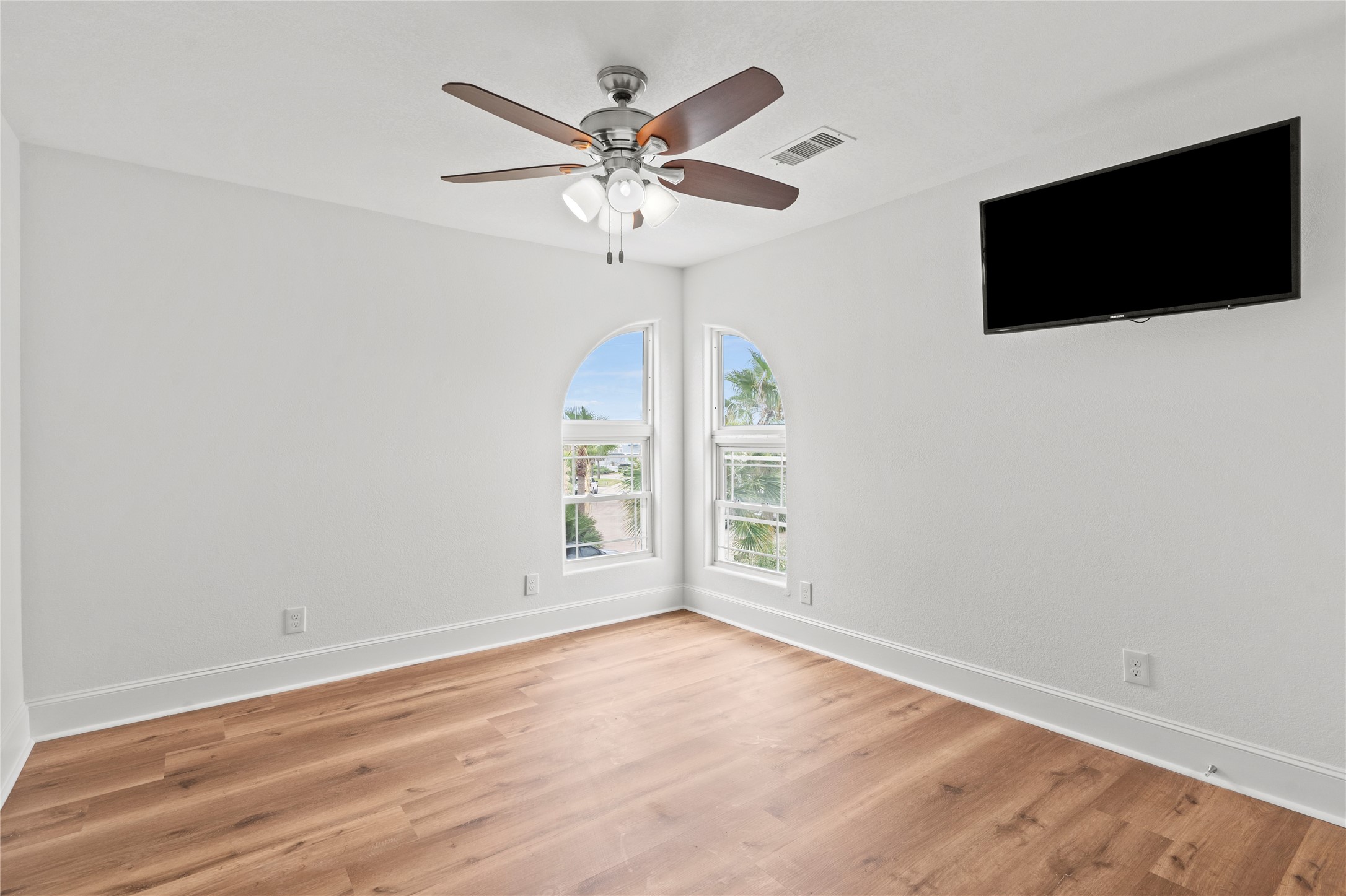 407 Isles End Road Tiki Island, TX 77554 - Photo 16 of 34 an empty room with wooden floor fan and windows