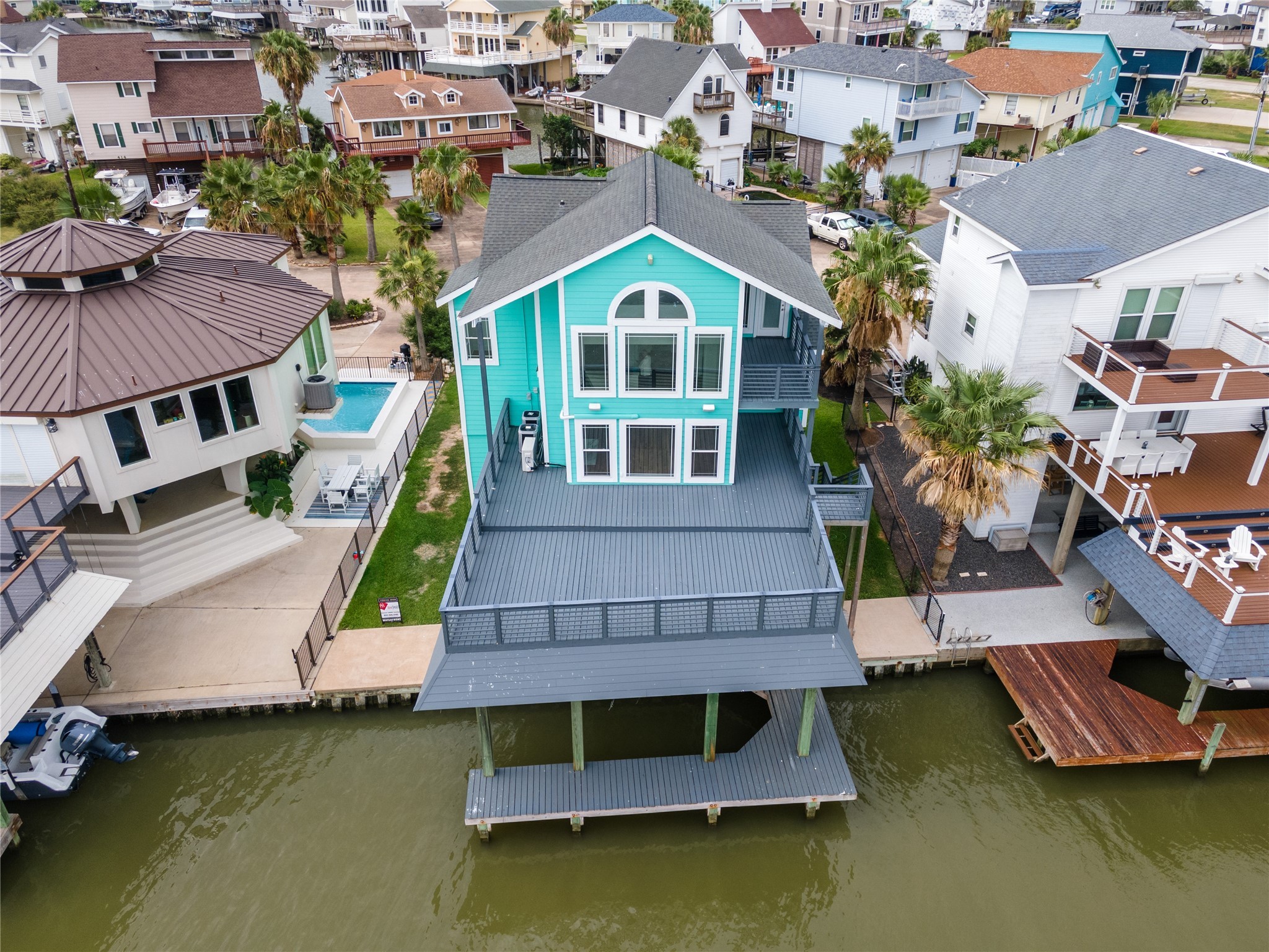 407 Isles End Road Tiki Island, TX 77554 - Photo 2 of 34 an aerial view of a house with swimming pool and a lounge chairs
