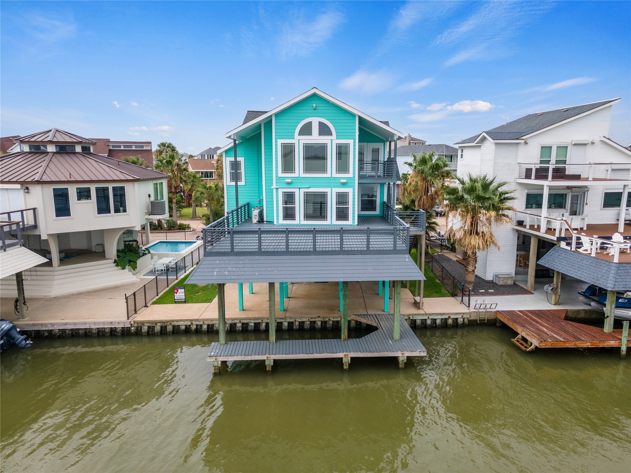 407 Isles End Road Tiki Island, TX 77554 - Photo 5 of 34 a front view of a house with a large pool and a yard
