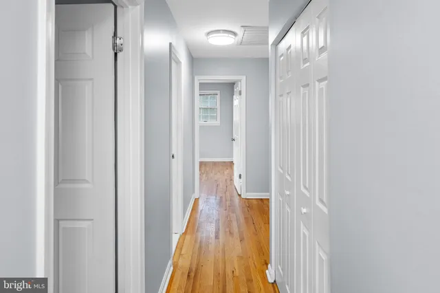 a view of a hallway with wooden floor