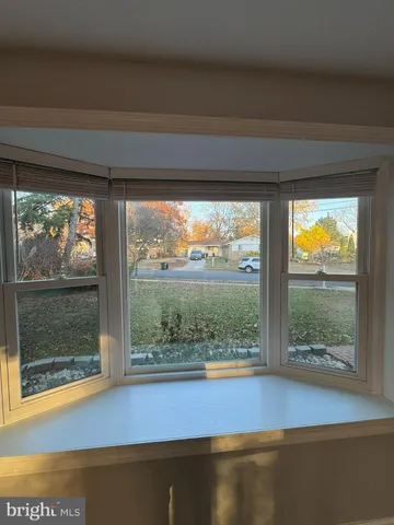 a view of empty room with floor to ceiling window and wooden floor