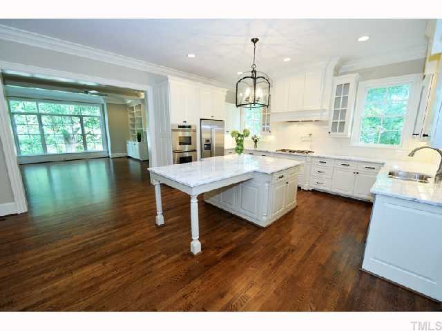 2804 Rothgeb Drive Raleigh, NC 27609 - Photo 4 of 8 a open kitchen with granite countertop stove sink and white cabinets with wooden floor