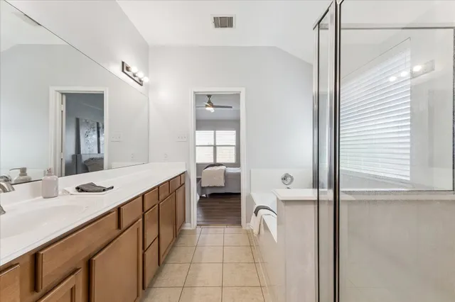 a bathroom with a double vanity sink a mirror and a bathtub