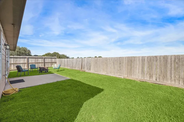 a view of yard with swimming pool and wooden fence