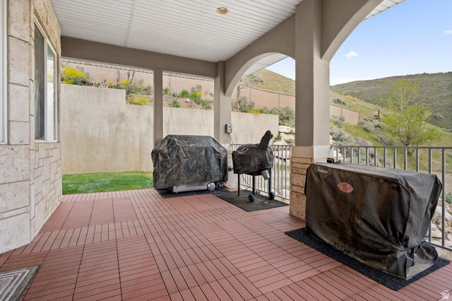 708 Eagle Rdg Drive Bountiful, UT 84010 - Photo 20 of 69 Covered patio featuring red tile flooring, arched architectural supports, and a slatted ceiling