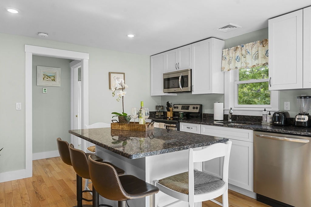 4 Hye Lane Edgartown, MA 02539 - Photo 27 of 41 a kitchen with granite countertop a stove a sink a dining table and chairs