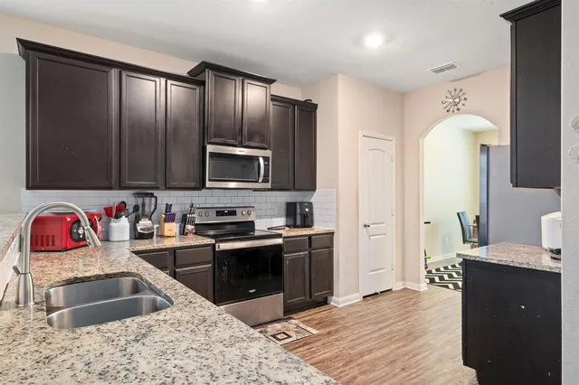 a kitchen with stainless steel appliances granite countertop a sink stove and refrigerator