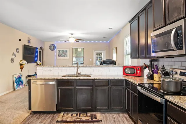 a kitchen with stainless steel appliances granite countertop a sink stove and cabinets