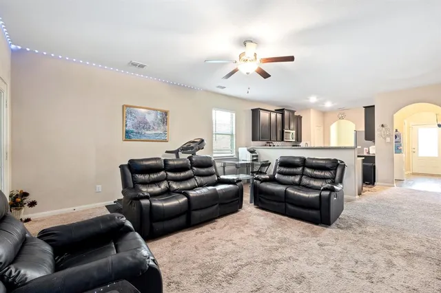 a living room with furniture and a chandelier