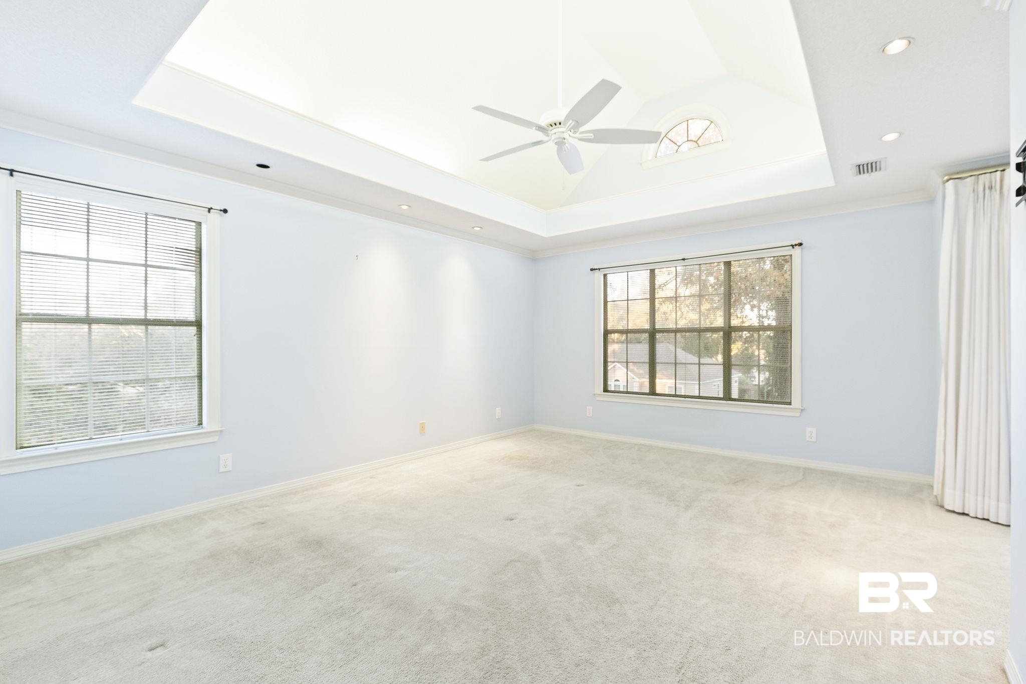 2100 Stonebrook Drive West Mobile, AL 36695 - Photo 27 of 60 Primary bedroom with light carpet, a raised ceiling, a wealth of natural light, and ceiling fan