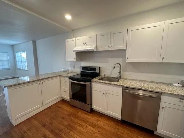 a kitchen with granite countertop white cabinets and white appliances