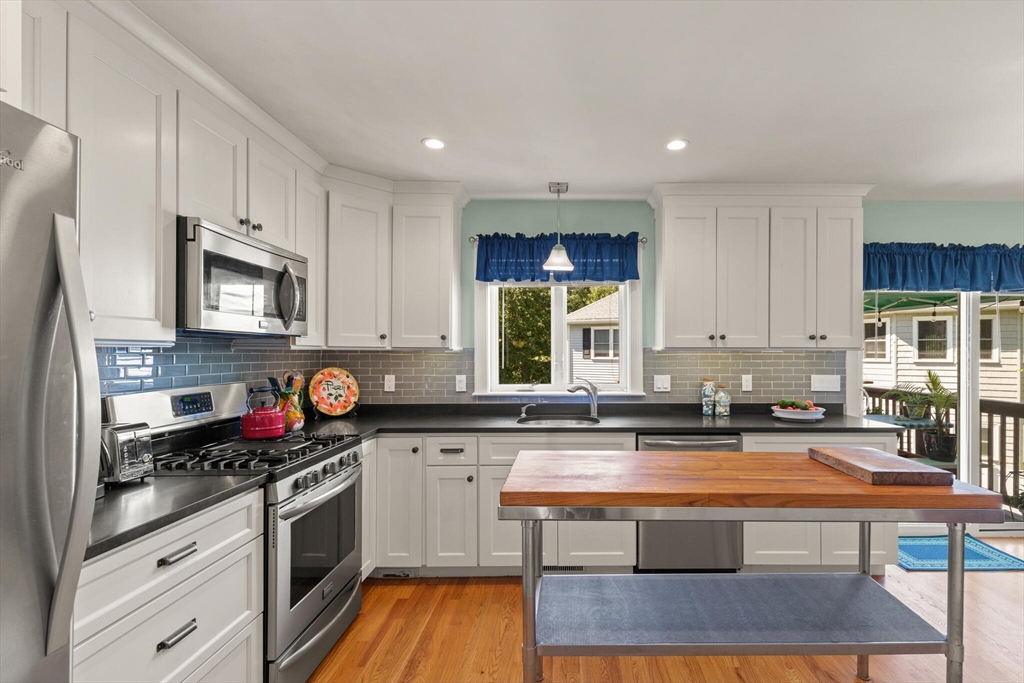 6 Ferry Road, Unit A Salisbury, MA 01952 - Photo 11 of 28 a kitchen with kitchen island granite countertop a stove a sink and a microwave