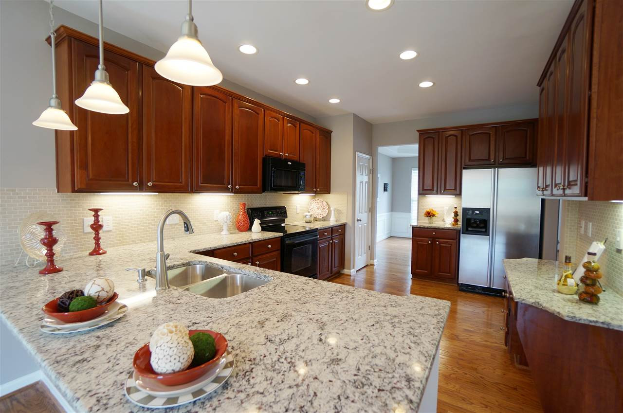 7730 San Gabriel Street Raleigh, NC 27613 - Photo 4 of 25 Spacious kitchen has an open layout, granite counter tops, tile back splash, under cabinet lighting, charm, style & sophistication. Kitchen