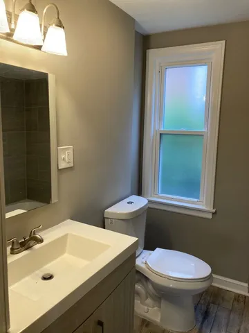 a bathroom with a sink toilet and window