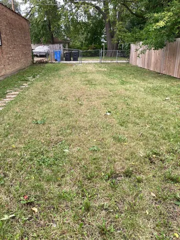 a view of a house with a yard and sitting area