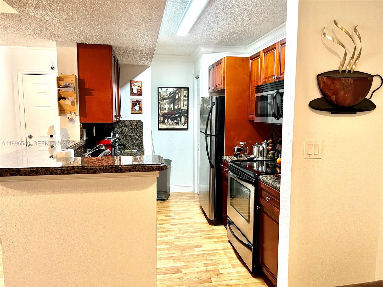 15689 Southwest 106th Lane, Unit 706 Miami, FL 33196 - Photo 11 of 23 a kitchen with stainless steel appliances granite countertop a sink stove and refrigerator