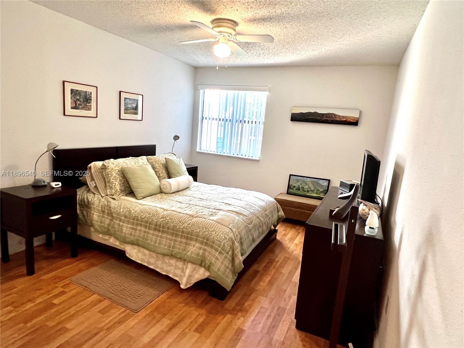 15689 Southwest 106th Lane, Unit 706 Miami, FL 33196 - Photo 13 of 23 a bedroom with a bed and wooden floor