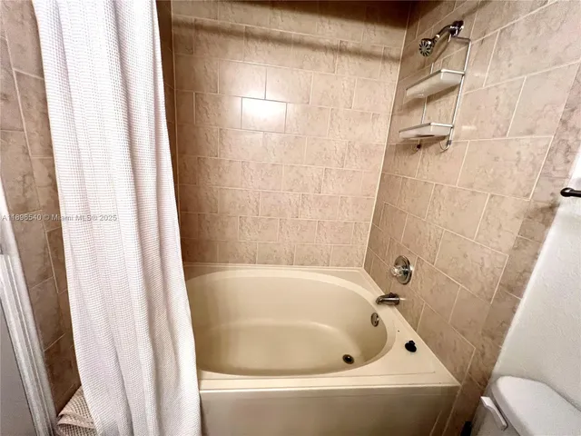 a white bath tub and shower curtain