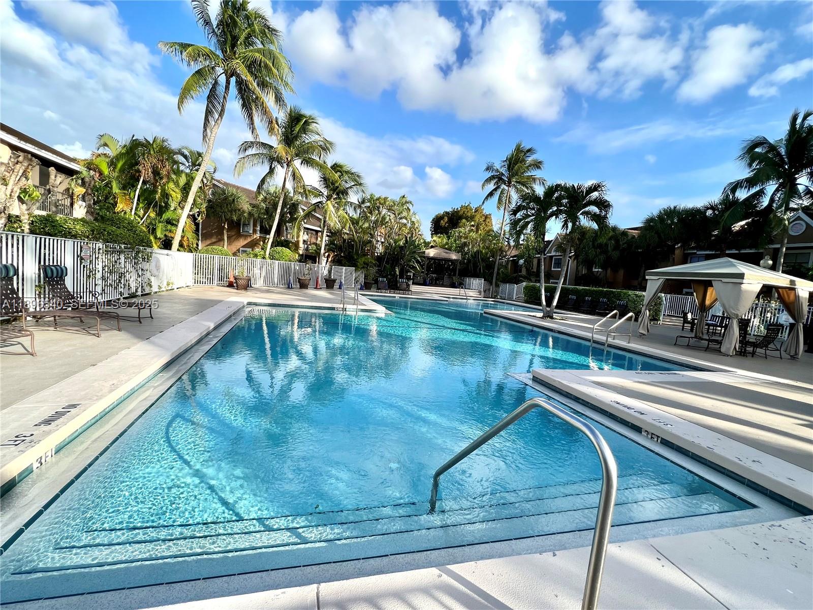 15689 Southwest 106th Lane, Unit 706 Miami, FL 33196 - Photo 19 of 23 a view of a swimming pool with a patio