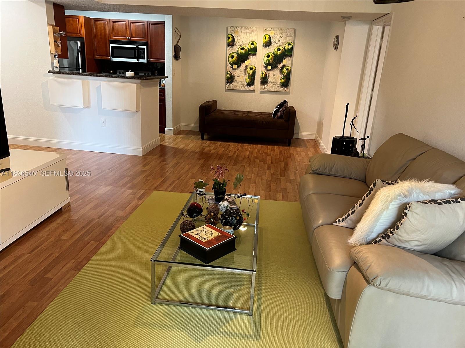 15689 Southwest 106th Lane, Unit 706 Miami, FL 33196 - Photo 3 of 23 a living room with furniture and a flat screen tv