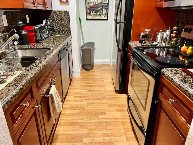 a kitchen with stainless steel appliances granite countertop a stove and a refrigerator