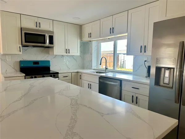 a kitchen with stainless steel appliances a refrigerator stove microwave and sink