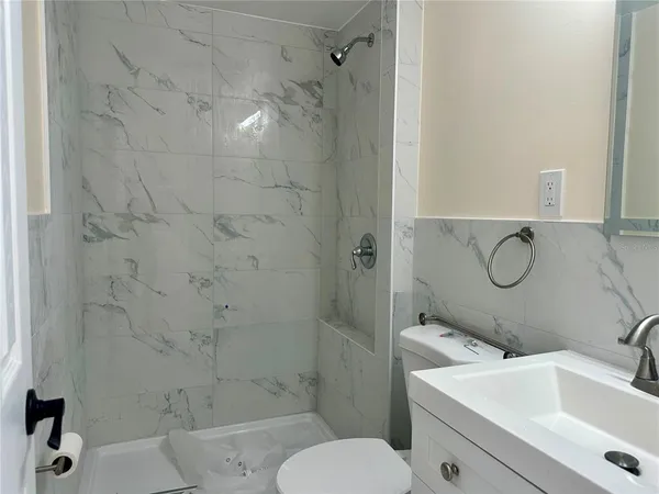 a bathroom with a sink a toilet and shower