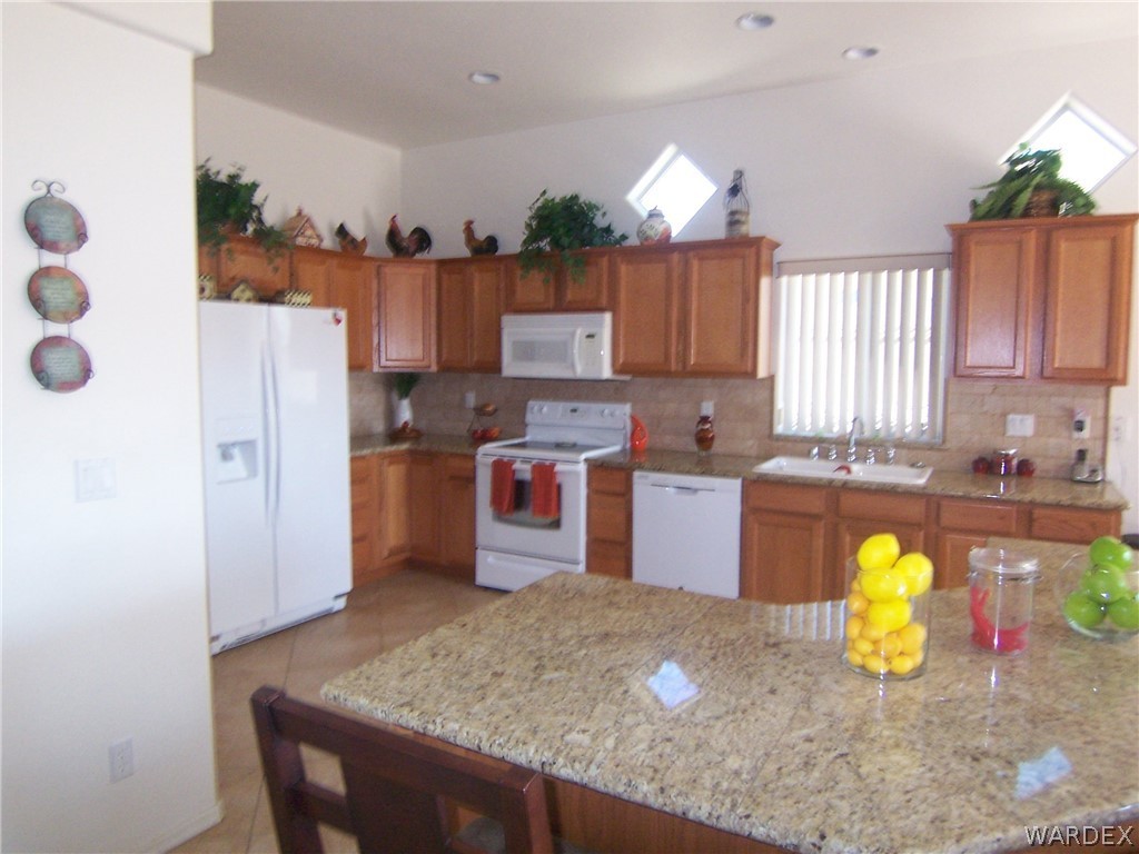 2340 Corwin Road Bullhead City, AZ 86442 - Photo 7 of 38 a kitchen with a refrigerator a stove and a sink