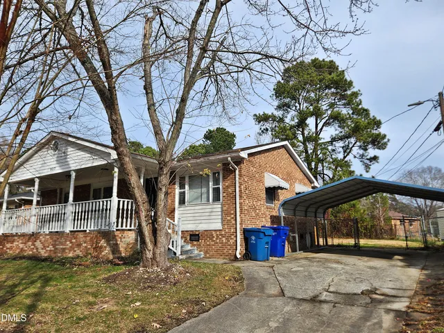 a view of a house with large trees and playing area