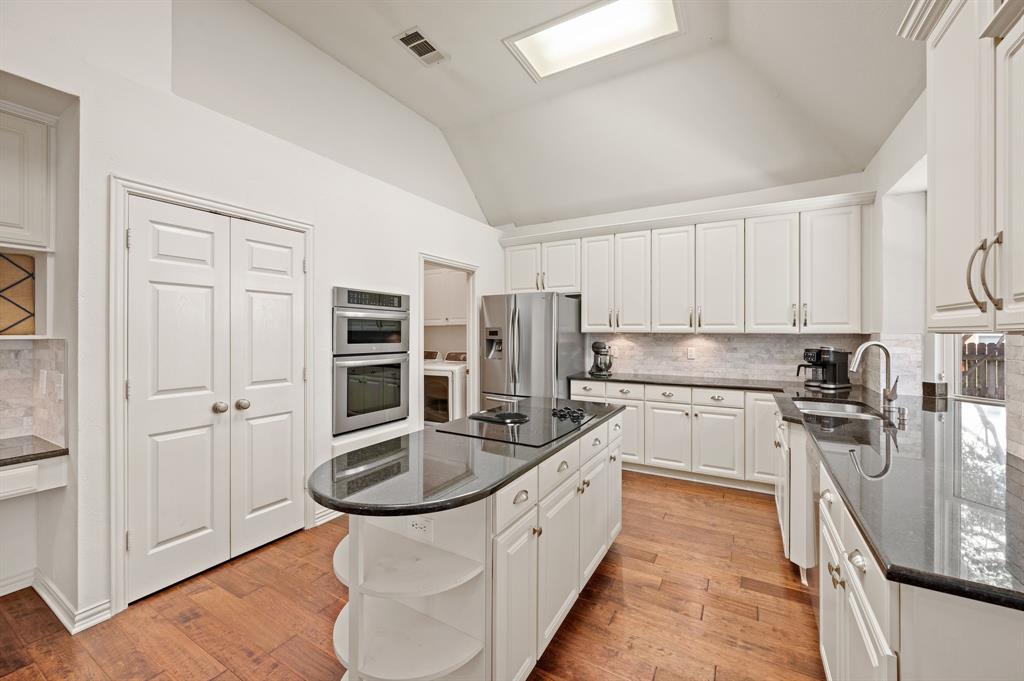 2532 Springhill Drive Grapevine, TX 76051 - Photo 12 of 40 Island Kitchen has granite counters, white marble backsplash and lovely view of the pretty backyard