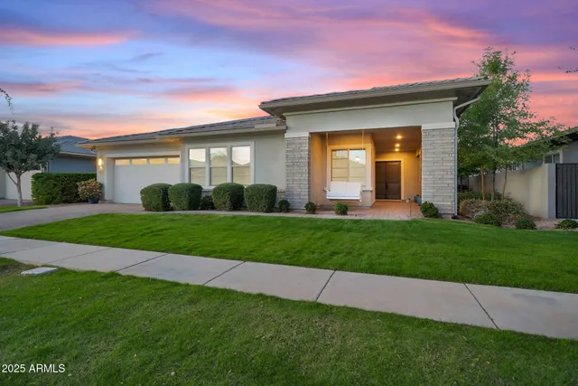 a view of a white house next to a yard with big trees
