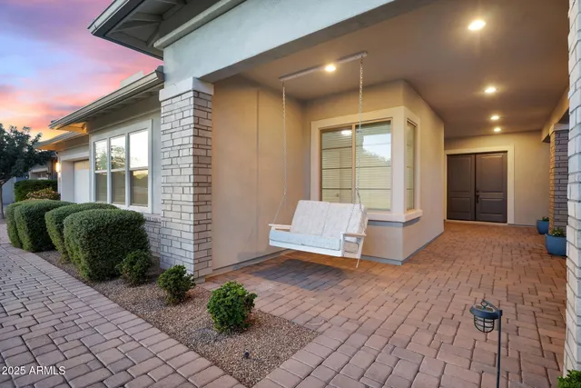 a front view of a house with a yard and potted plants