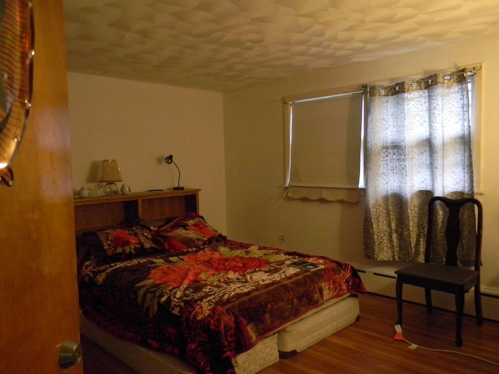 190 Ridge Road Revere, MA 02151 - Photo 9 of 13 a bedroom with a bed and wooden floor