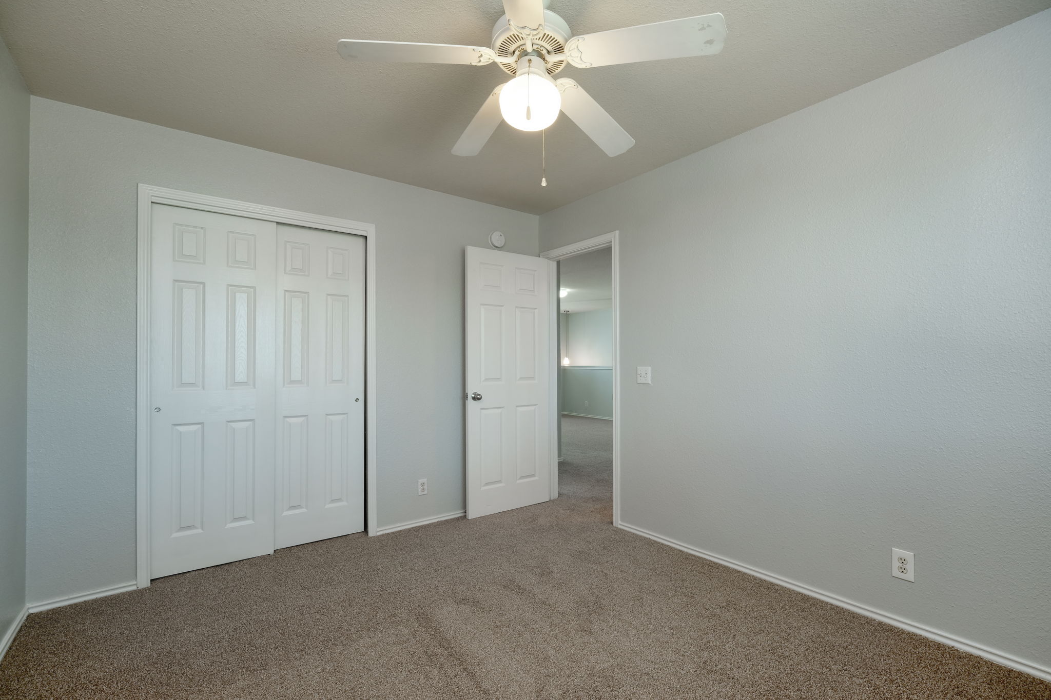 14312 Cummins Way Manor, TX 78653 - Photo 11 of 13 an empty room with a chandelier fan and closet area