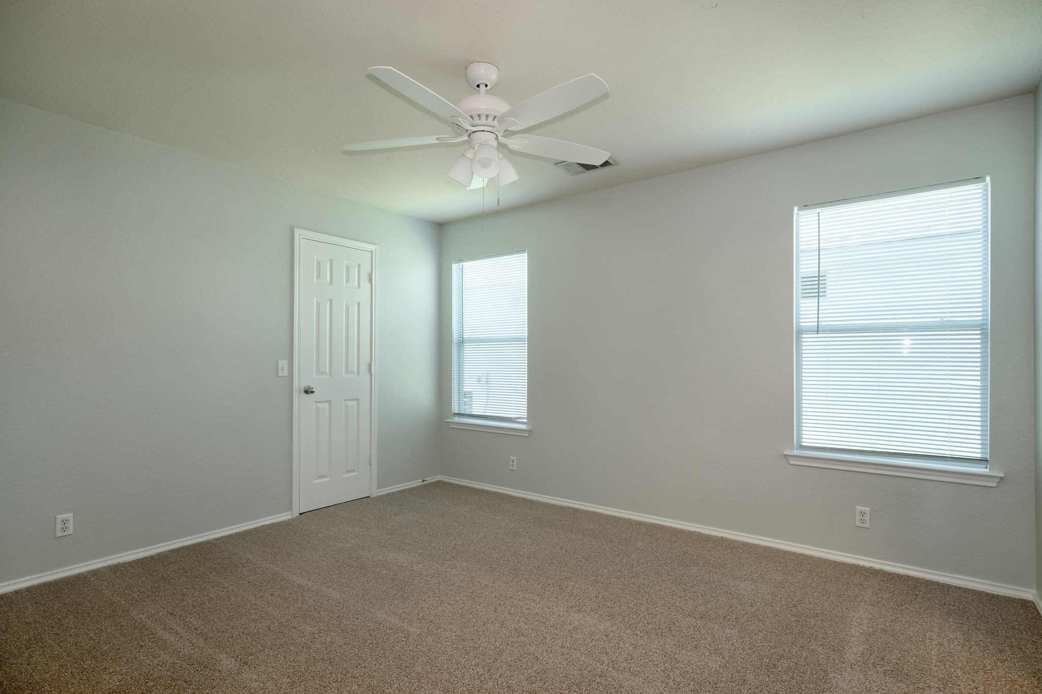 14312 Cummins Way Manor, TX 78653 - Photo 6 of 13 an empty room with windows and fan