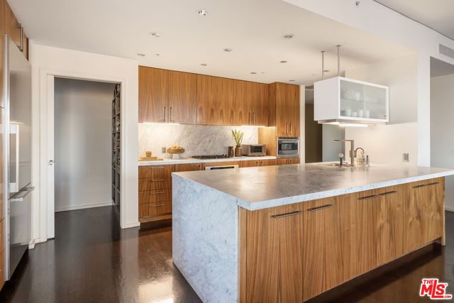 a kitchen with granite countertop a sink a counter top space and cabinets