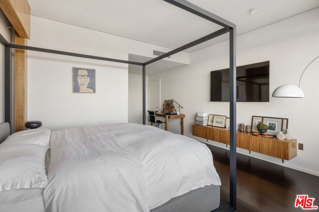 a bedroom with a bed and flat screen tv