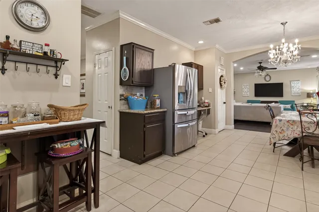 a kitchen with stainless steel appliances a stove refrigerator a sink dishwasher with a dining table and chairs