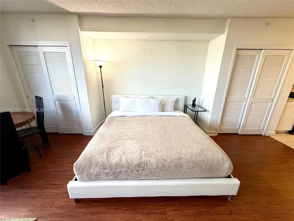 a large white bed sitting in a room next to a window