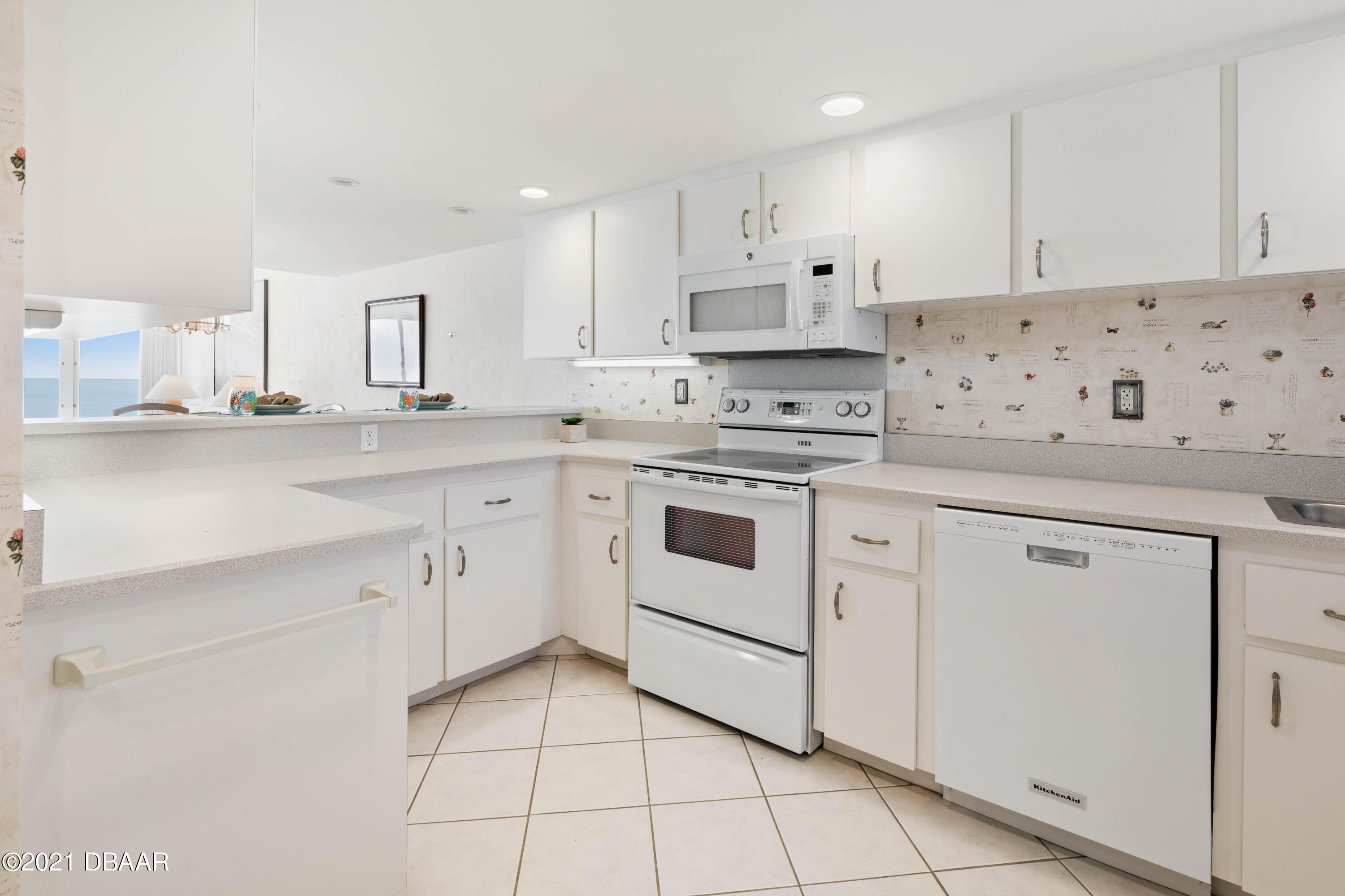 1051 Ocean Shore Boulevard, Unit 1102 Ormond Beach, FL 32176 - Photo 7 of 29 a kitchen with white cabinets appliances and sink