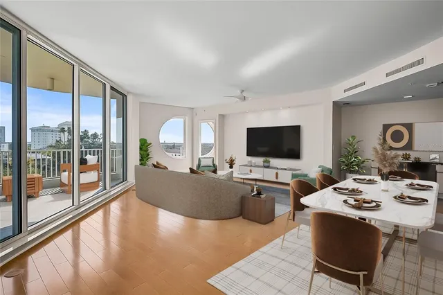 a living room with furniture a flat screen tv and a large window