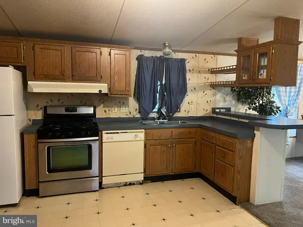 a kitchen with granite countertop a sink stove and cabinets