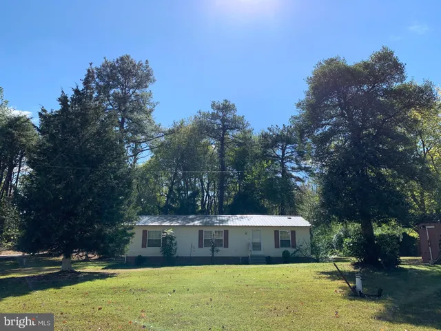a view of house with yard and trees in the background