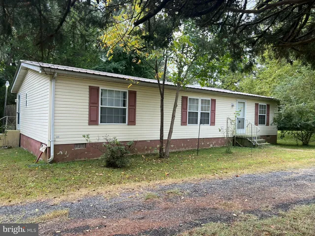 a front view of a house with a garden and trees